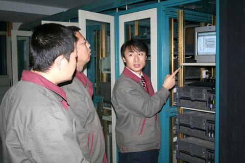 图为该厂信息技术人员正在查看生产信息备份数据系统的运转情况.